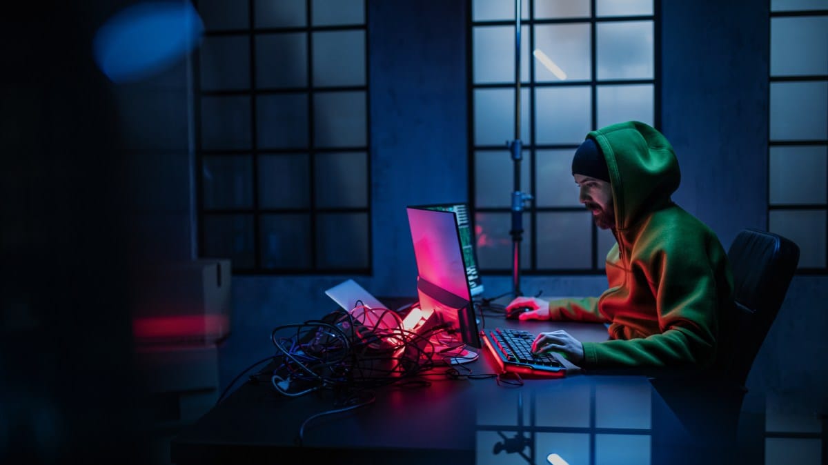 Hacker working at computer in dark office